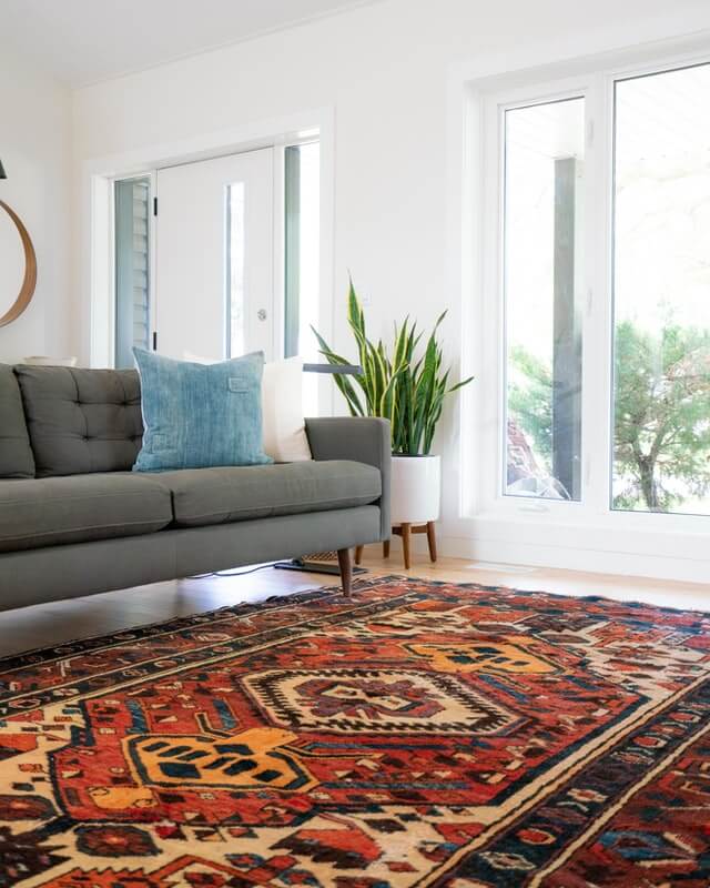Gray fabric couch and Persian rug. Picture of a finished carpet cleaners job in cairns.