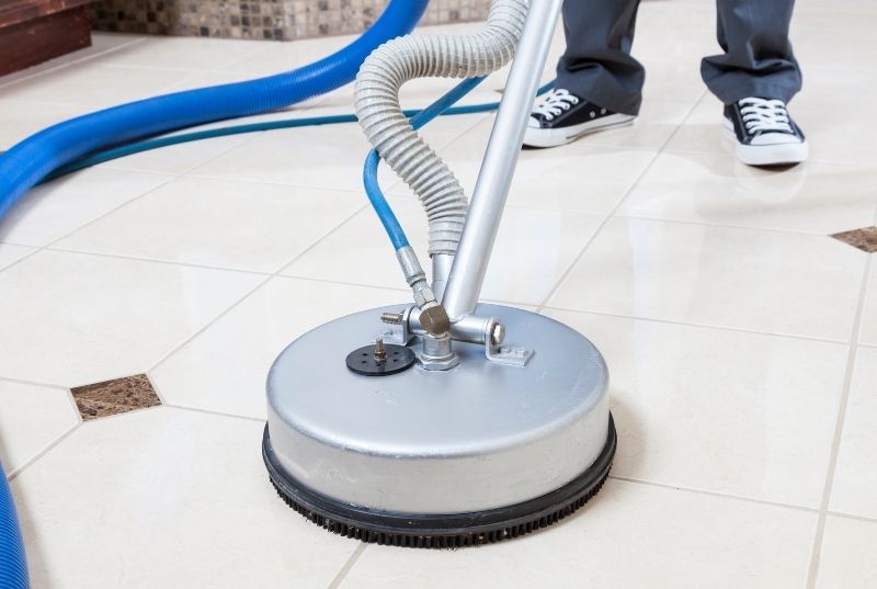 Cleaner using a tile cleaning machine on a commercial floor tile
