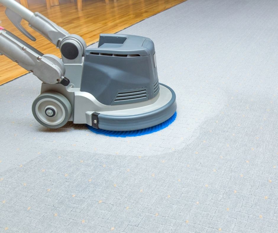 Rotary carpet cleaning machine buffing a carpet floor
